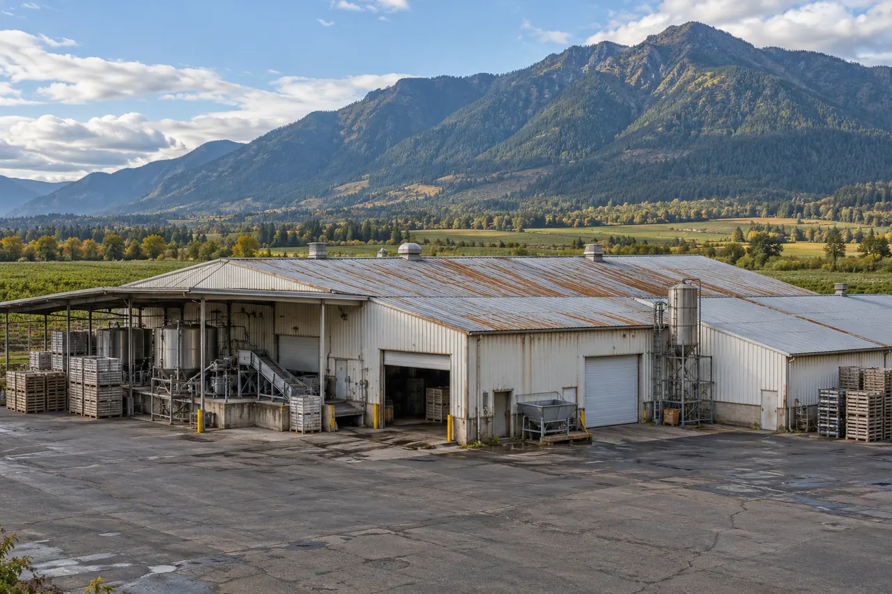 Older metal agricultural processing building with a rust-streaked roof